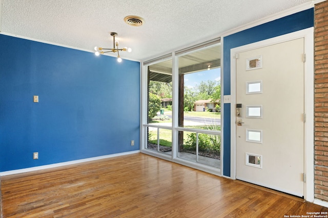 250 Maplewood, San Antonio, TX 78216 - spare room with a chandelier, wood finished floors, a textured ceiling, and expansive windows