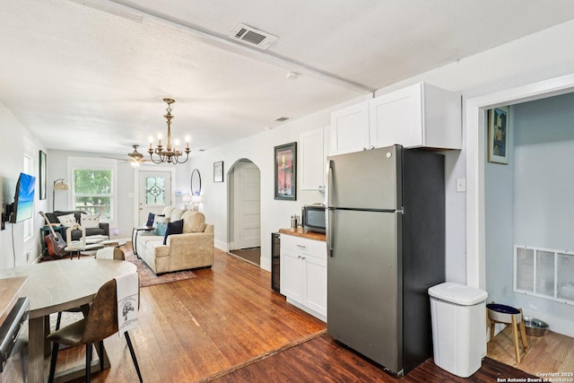107 W Gilbert, Falls City, TX 78113 - kitchen featuring appliances with stainless steel finishes, arched walkways, white cabinetry, and dark wood-style flooring