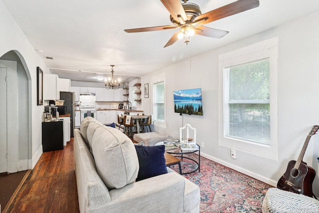 107 W Gilbert, Falls City, TX 78113 - living area featuring a chandelier, arched walkways, ceiling fan, and dark wood finished floors