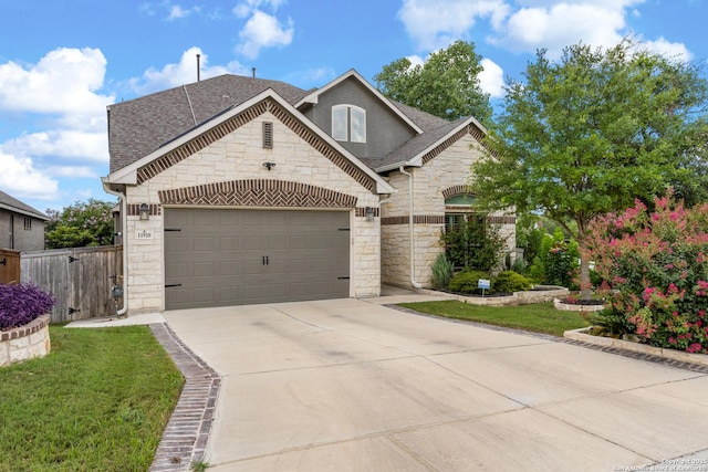 11910 Wilby, San Antonio, TX 78253 - french country home featuring stone siding, roof with shingles, concrete driveway, and a garage
