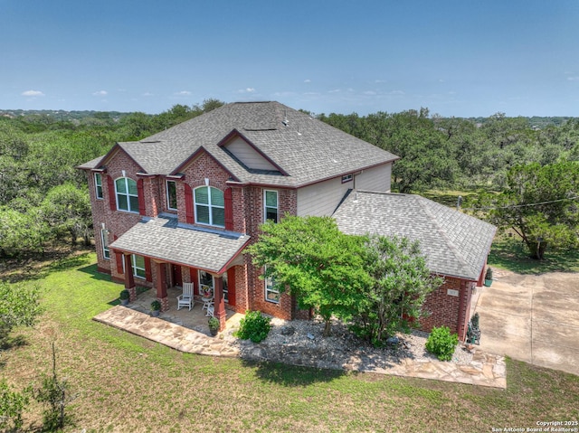 577 River Chase, New Braunfels, TX 78132 - view of front of home featuring brick siding, a front lawn, covered porch, and roof with shingles
