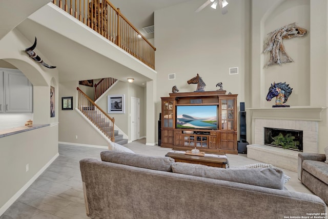 577 River Chase, New Braunfels, TX 78132 - living room with light marble finish flooring, stairs, a ceiling fan, a high ceiling, and a brick fireplace