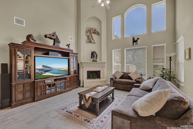 577 River Chase, New Braunfels, TX 78132 - living room with a towering ceiling, a ceiling fan, a brick fireplace, and wood finished floors
