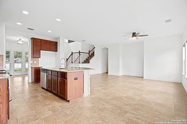 105 Highland Pl, Cibolo, TX 78108 - kitchen with arched walkways, a ceiling fan, stainless steel dishwasher, light stone counters, and recessed lighting
