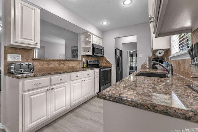 139 Navajo Cir, Cibolo, TX 78108 - kitchen featuring appliances with stainless steel finishes, white cabinets, tasteful backsplash, dark stone counters, and recessed lighting