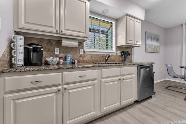139 Navajo Cir, Cibolo, TX 78108 - kitchen featuring stainless steel dishwasher, white cabinetry, backsplash, light wood finished floors, and dark stone countertops