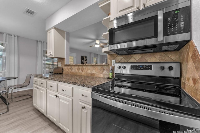 139 Navajo Cir, Cibolo, TX 78108 - kitchen featuring electric range oven, stainless steel microwave, ceiling fan, tasteful backsplash, and white cabinets