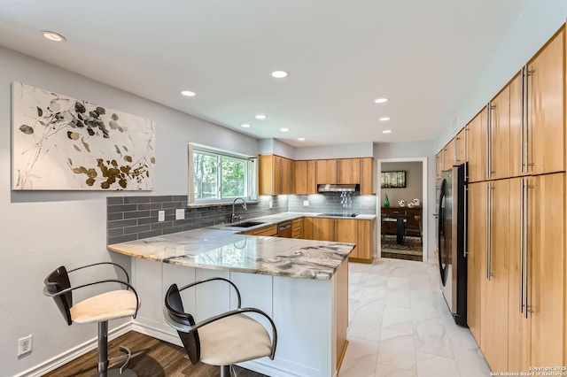14339 Hill Prince, San Antonio, TX 78248 - kitchen featuring a peninsula, light stone countertops, freestanding refrigerator, a kitchen bar, and black electric cooktop