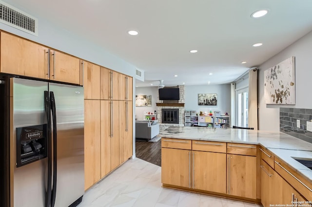 14339 Hill Prince, San Antonio, TX 78248 - kitchen with stainless steel refrigerator with ice dispenser, a fireplace, a peninsula, light stone countertops, and open floor plan