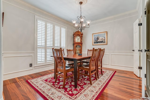 13610 Pearlstone, San Antonio, TX 78232 - dining area with a decorative wall, a chandelier, crown molding, wood finished floors, and a wainscoted wall