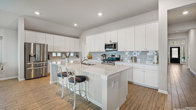 5322 Silent Dusk, Bulverde, TX 78163 - kitchen with stainless steel appliances, light wood finished floors, decorative backsplash, light countertops, and lofted ceiling