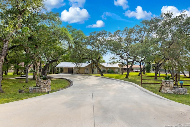 611 Wild Turkey, New Braunfels, TX 78132 - view of front of house featuring curved driveway, a front lawn, and a detached carport