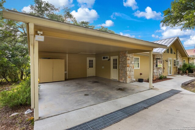 611 Wild Turkey, New Braunfels, TX 78132 - view of front of home featuring a standing seam roof, a carport, stone siding, and a metal roof
