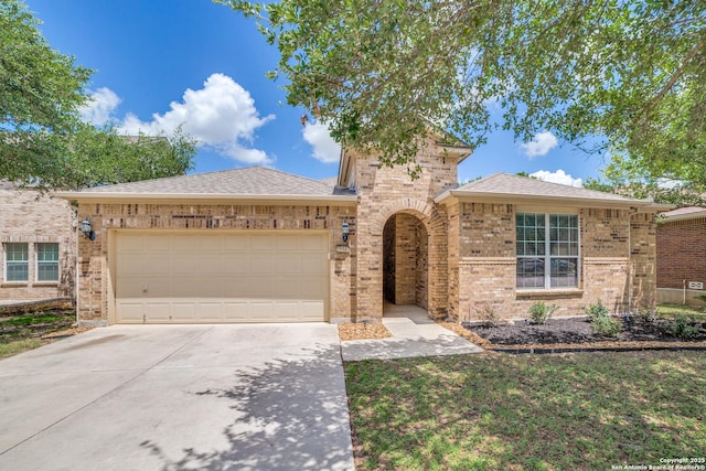 25547 Veining, San Antonio, TX 78261 - view of front of house with concrete driveway, an attached garage, brick siding, and roof with shingles