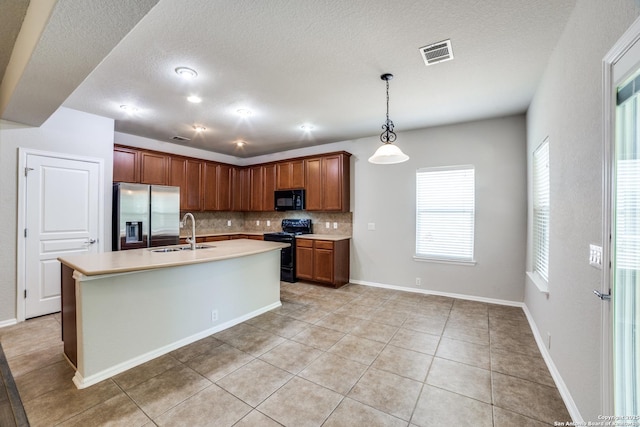 25547 Veining, San Antonio, TX 78261 - kitchen with black appliances, backsplash, light countertops, light tile patterned floors, and decorative light fixtures