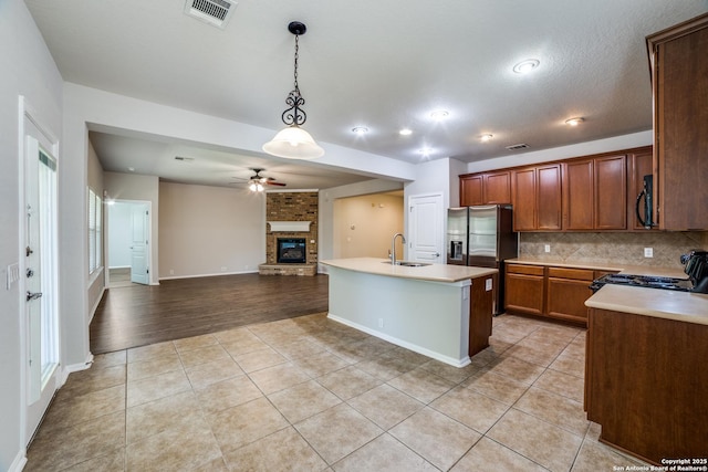 25547 Veining, San Antonio, TX 78261 - kitchen with black appliances, a ceiling fan, a fireplace, light tile patterned floors, and open floor plan