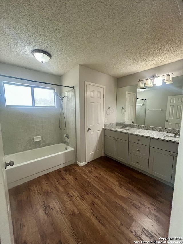 8602 Wood Peak, San Antonio, TX 78251 - bathroom featuring wood finished floors, shower / washtub combination, double vanity, and a textured ceiling
