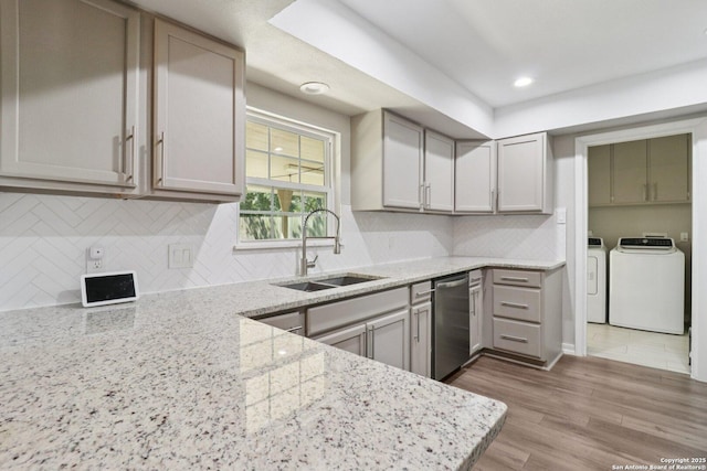 1710 Searcy, San Antonio, TX 78232 - kitchen featuring washing machine and dryer, dishwasher, light stone countertops, decorative backsplash, and light wood-style flooring