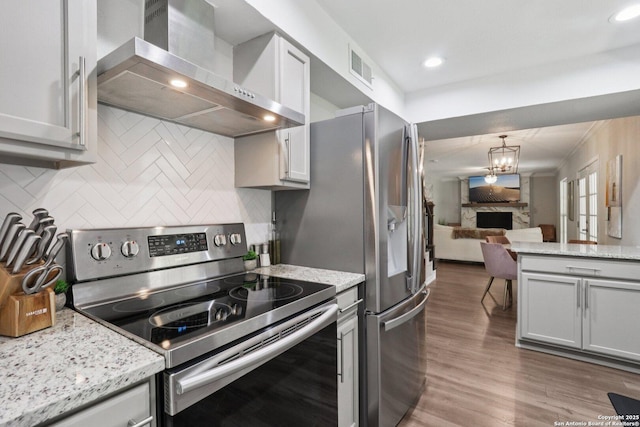 1710 Searcy, San Antonio, TX 78232 - kitchen featuring stainless steel electric range oven, wall chimney exhaust hood, wood finished floors, tasteful backsplash, and open floor plan