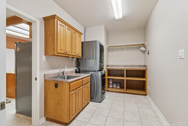 127 Sunflower Ln, San Antonio, TX 78213 - laundry room featuring stacked washer and clothes dryer, cabinet space, and light tile patterned flooring