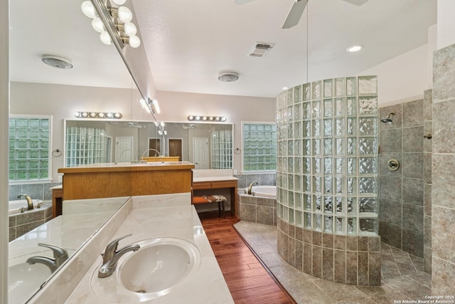 127 Sunflower Ln, San Antonio, TX 78213 - bathroom with a bath, two vanities, wood finished floors, a walk in shower, and a ceiling fan