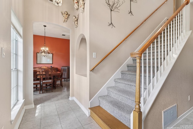 127 Sunflower Ln, San Antonio, TX 78213 - stairs with a towering ceiling, a chandelier, tile patterned floors, and arched walkways