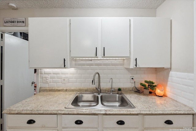 5311 Light House, San Antonio, TX 78242 - kitchen with light countertops, decorative backsplash, white cabinets, and a textured ceiling
