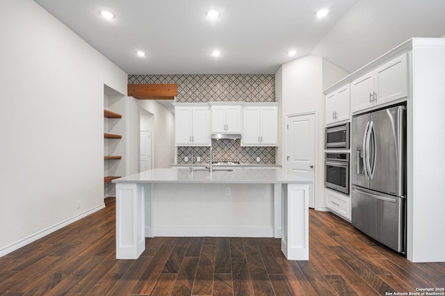 101 Boulder Crk, Boerne, TX 78006 - kitchen with appliances with stainless steel finishes, light countertops, white cabinetry, a center island with sink, and under cabinet range hood