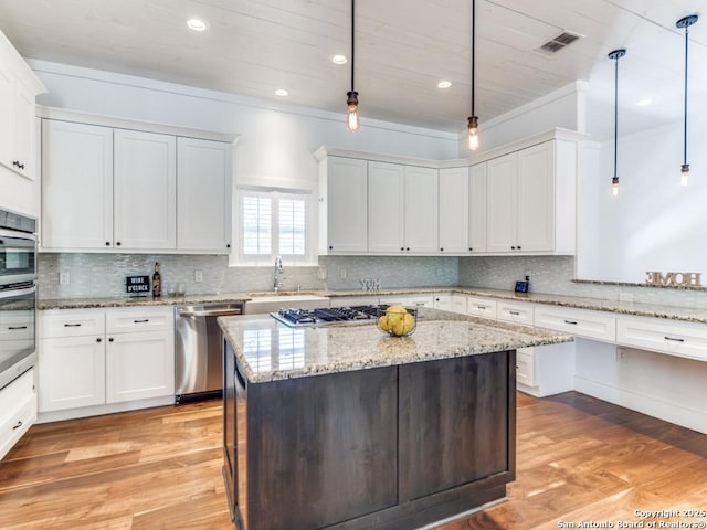 2521 Bay Hl, Bulverde, TX 78163 - kitchen featuring appliances with stainless steel finishes, white cabinets, light wood-style floors, a center island, and recessed lighting