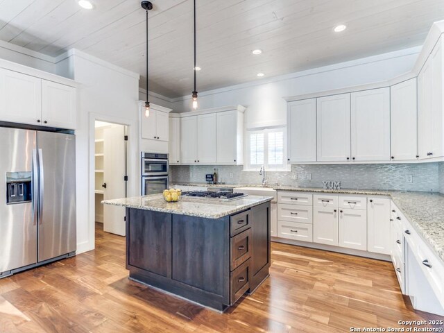 2521 Bay Hl, Bulverde, TX 78163 - kitchen featuring stainless steel appliances, white cabinets, a center island, hanging light fixtures, and backsplash