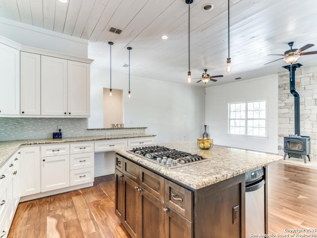 2521 Bay Hl, Bulverde, TX 78163 - kitchen featuring a ceiling fan, stainless steel gas stovetop, a wood stove, open floor plan, and light wood finished floors