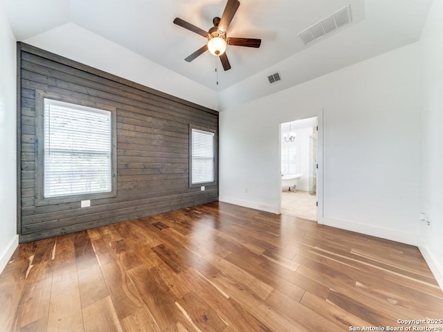 2521 Bay Hl, Bulverde, TX 78163 - spare room featuring ceiling fan, hardwood / wood-style floors, lofted ceiling, wooden walls, and a chandelier