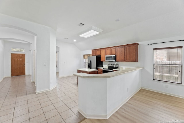 153 Bison Ln, Cibolo, TX 78108 - kitchen with appliances with stainless steel finishes, vaulted ceiling, light countertops, arched walkways, and a peninsula