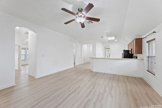 153 Bison Ln, Cibolo, TX 78108 - unfurnished living room with arched walkways, light wood-style floors, a ceiling fan, and lofted ceiling