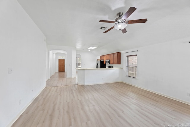 153 Bison Ln, Cibolo, TX 78108 - unfurnished living room with arched walkways, a ceiling fan, light wood-style flooring, and vaulted ceiling