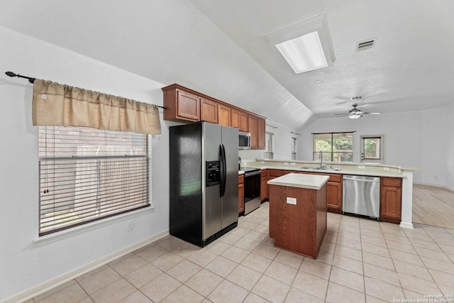 153 Bison Ln, Cibolo, TX 78108 - kitchen featuring stainless steel appliances, a peninsula, light countertops, lofted ceiling, and a center island