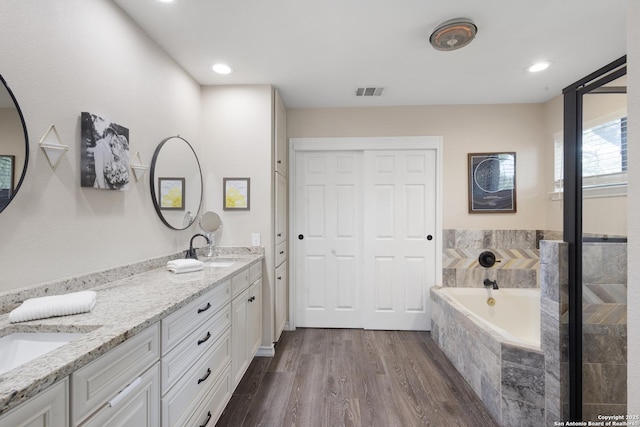 21005 Hickory Bnd, Garden Ridge, TX 78266 - bathroom with double vanity, a garden tub, wood finished floors, and recessed lighting
