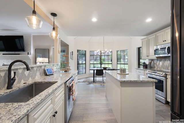 21005 Hickory Bnd, Garden Ridge, TX 78266 - kitchen featuring stainless steel appliances, tasteful backsplash, a chandelier, a kitchen island, and light wood finished floors