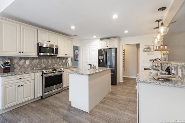 21005 Hickory Bnd, Garden Ridge, TX 78266 - kitchen with stainless steel appliances, a center island, backsplash, light wood-style floors, and recessed lighting