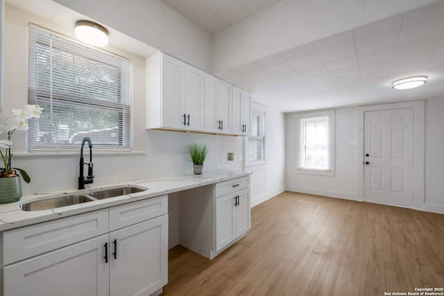 1002 Aganier, San Antonio, TX 78212 - kitchen with light wood finished floors, tasteful backsplash, white cabinetry, and light stone counters