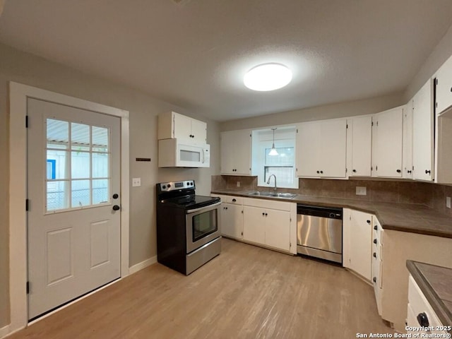 443 Seele, New Braunfels, TX 78130 - kitchen featuring stainless steel appliances, light wood-style flooring, healthy amount of natural light, and white cabinets