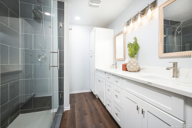 559 W Nacogdoches St, New Braunfels, TX 78130 - bathroom featuring double vanity, a stall shower, and wood finished floors