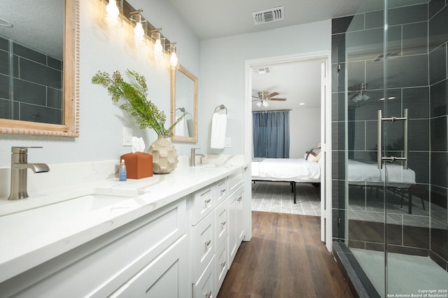 559 W Nacogdoches St, New Braunfels, TX 78130 - full bathroom featuring double vanity, wood finished floors, a ceiling fan, a shower stall, and connected bathroom
