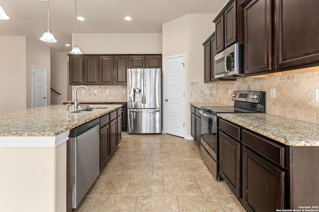 601 Saddle Villa, Cibolo, TX 78108 - kitchen featuring stainless steel appliances, dark brown cabinetry, decorative backsplash, light stone countertops, and a center island with sink