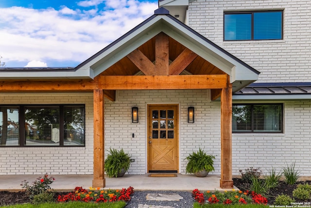 134 School, Poteet, TX 78065 - entrance to property featuring a standing seam roof, brick siding, and a metal roof
