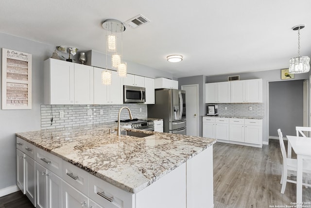 1654 Rob Roy, San Antonio, TX 78251 - kitchen with appliances with stainless steel finishes, a chandelier, tasteful backsplash, and light stone countertops