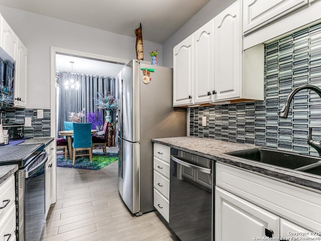 1 Towers Park Unit 211, San Antonio, TX 78209 - kitchen featuring appliances with stainless steel finishes, backsplash, white cabinets, and a chandelier
