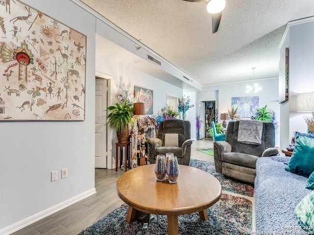 1 Towers Park Unit 211, San Antonio, TX 78209 - living room with light wood-style flooring, ceiling fan, a textured ceiling, and a chandelier