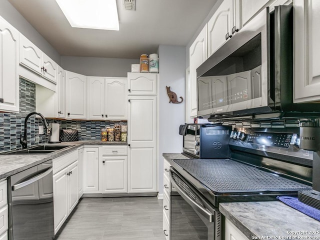 1 Towers Park Unit 211, San Antonio, TX 78209 - kitchen featuring appliances with stainless steel finishes, decorative backsplash, and white cabinets