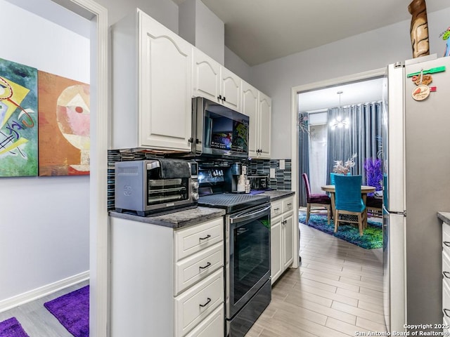 1 Towers Park Unit 211, San Antonio, TX 78209 - kitchen featuring stainless steel appliances, backsplash, a chandelier, white cabinetry, and light wood-style floors